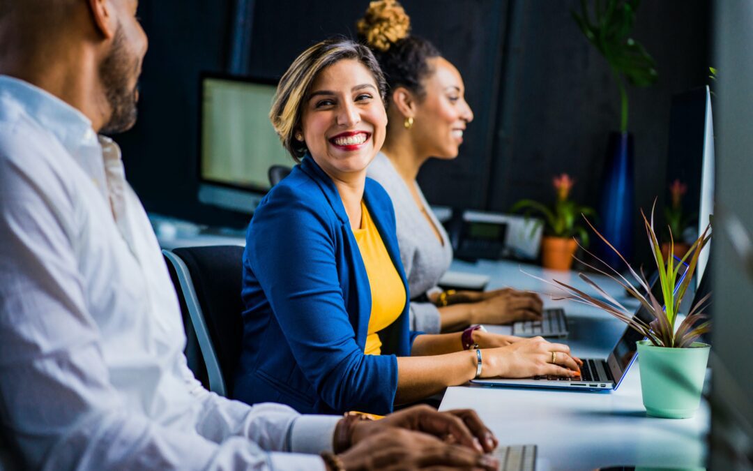 Woman on her computer smiling at her coworker